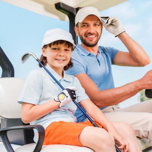 two-smiling-golfers-happy-young-man-and-his-littl-2023-11-27-05-17-52-utc.jpg